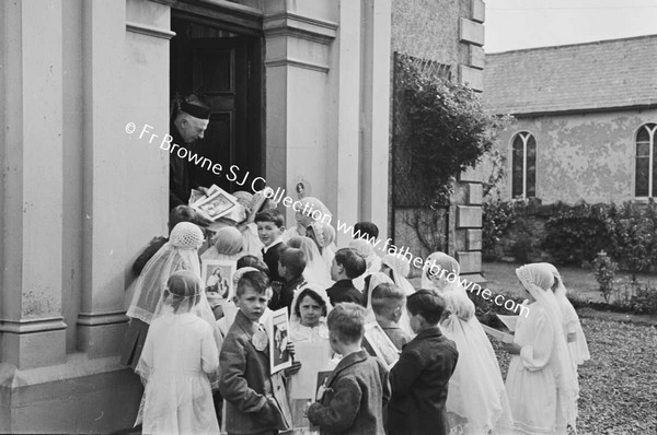 PARISH SCENE  GROUP OF CHILDREN WITH PRIEST ON DOORSTEP OF HOUSE